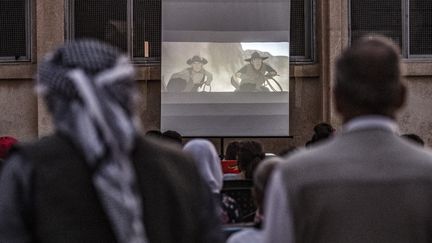 Des spectateurs se rassemblent dans devant un écran de cinéma disposé dans une cour d'école du village de Shaghir Bazar, au Nord-Est de la Syrie.&nbsp; (DELIL SOULEIMAN / AFP)