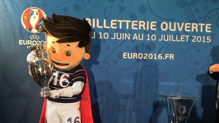 Super Victor, la mascotte de l'Euro 2016, tient une r&eacute;plique de la coupe durant une pr&eacute;sentation de la billetterie mise en place par l'UEFA, le 12 mai 2015. (GERD ROTH / DPA / AFP)