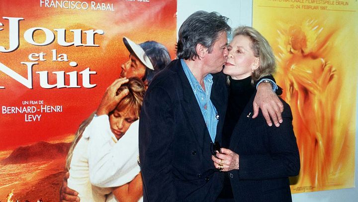 Alain Delon embrasse sa partenaire de jeu Lauren Bacall, en pleine promotion du film "Le Jour et la Nuit" (1997) de Bernard Henri-Lévy au festival de Berlin, en Allemagne, le 17 février 1997. (ADENIS/SIPA / SIPA)