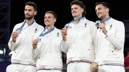 De gauche à droite, Lucas Dussoulier, Timothé Vergiat, Jules Rambaut et Franck Seguela posent avec leur médaille d'argent obtenue en basket 3x3 masculin, lundi 5 août 2024, à Paris. (DAVID GRAY / AFP)