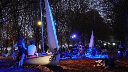 La nuit vient tout juste de tomber. Avant de rejoindre les pionniers de l'electro Kraftwerk, les festivaliers&nbsp;rechargent les batteries&nbsp;dans des hamacs et des barques&nbsp;installés à cet effet par l'équipe du&nbsp;festival Rock en Seine. (NISRINE MANAI / FRANCEINFO CULTURE)