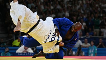 Légendaire ! Une semaine après avoir allumé la vasque olympique, Teddy Riner a prouvé que sa place était tout en haut de l'Olympe avec un troisième titre olympique en individuel. Même le numéro 1 mondial et champion du monde en titre n'a pas résisté au Français et a fini la finale sur le dos. (LUIS ROBAYO / AFP)