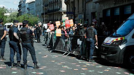 Des manifestants écologistes bloquent l'entrée de la salle Pleyel à l'heure de l'assemblée générale du groupe TotalEnergies, le 25 mai 2022 à Paris. (CHRISTOPHE MICHEL / HANS LUCAS / AFP)