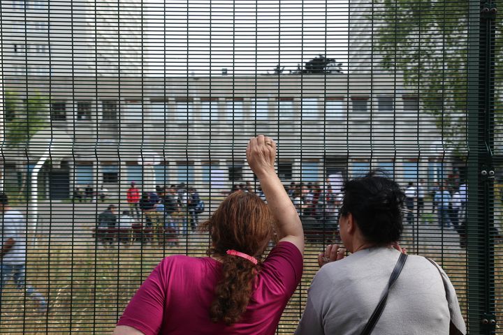 Deux femmes observent l'int&eacute;rieur du lyc&eacute;e&nbsp;occup&eacute; par des migrants et le collectif La Chapelle en lutte, le 31 juillet 2015, &agrave; Paris.&nbsp; (CITIZENSIDE/ANTHONY DEPERRAZ / CITIZENSIDE.COM)