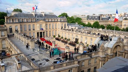 Journalistes, personnel de s&eacute;curit&eacute; et quelques spectateurs privil&eacute;gi&eacute;s ont investi les toits du palais de l'Elys&eacute;e. (MEHDI FEDOUACH / AFP)