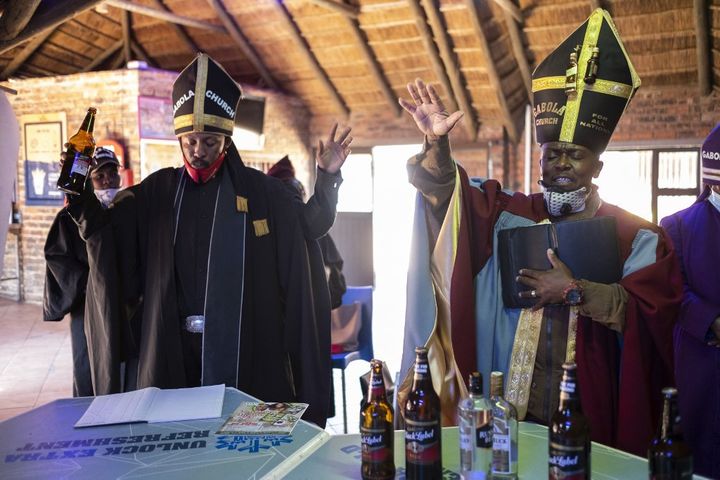 Tsietsi Makiti, fondateur de l'église Gabola, à droite sur l'image, en pleine célébration de la messe dominicale, dans la Bunny's Tavern, à Evaton. (WIKUS DE WET / AFP)