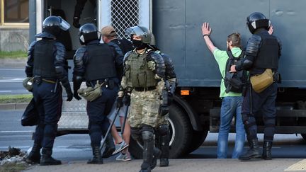 Des policiers détiennent des manifestants qui protestaient contre la réélection du président biélorusse&nbsp;Alexandre Loukachenko, à Minsk, le 11 août 2020. (SERGEI GAPON / AFP)