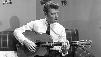 Avec une tenue de jeune garçon sage, il pose lors d'une séance de portraits dans les studios de la télévisions à Cognacq Jay, à Paris le 22 décembre 1961. (JEAN CLAUDE MALLINJOD / INA)