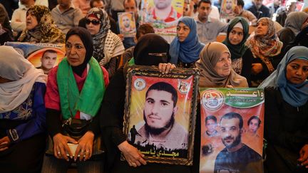 Des parents de prisonniers affichent des photos de détenus palestiniens lors d'un rassemblement devant le bâtiment de la Croix-Rouge internationale à Gaza le 8 mai 2017. Le mouvement, inédit depuis 2013, a été notamment lancé par Marwa Barghouthi, un des leaders de l'Intifada, condamné à la perpétuité par Israël. Les grévistes de la faim sont issus de toutes les mouvances politiques palestiniennes, du Fatah du président Mahmoud Abbas et de son rival Marwan Barghouthi, aux partis de la gauche en passant par le Hamas islamiste. La dernière grève massive dans les prisons israéliennes remonte à février 2013, lorsque 3.000 Palestiniens avaient refusé de se nourrir, durant une journée, pour protester contre la mort en détention d'un des leurs. Parmi les 6.500 Palestiniens actuellement détenus par Israël, figurent 62 femmes et 300 mineurs. Environ 500 d'entre eux sont placés sous le régime extra-judiciaire de la détention administrative qui permet une incarcération sans procès ni inculpation. Treize députés sont également emprisonnés. ( MUSTAFA HASSONA / ANADOLU AGENCY)