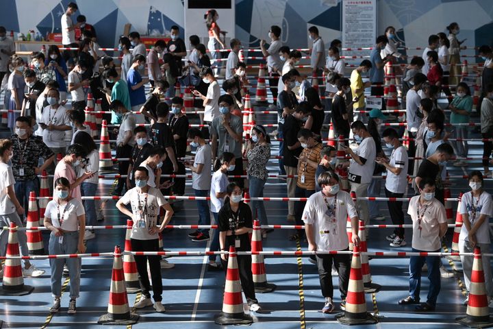 Une file d'attente pour un dépistage du Covid-19 organisé dans un gymnase de Wuhan (Chine), samedi 5 août 2021. (STR / AFP)