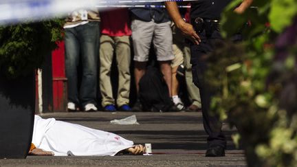 Un officier de la police de New York&nbsp;(Etats-Unis) se tient devant un cadavre apr&egrave;s la fusillade pr&egrave;s de l'Empire State Building, le 24 ao&ucirc;t 2012. (© LUCAS JACKSON / REUTERS / X90066)