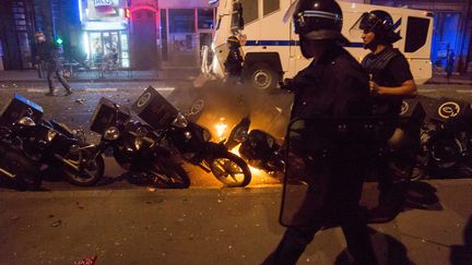 Des policiers passent devant des mobylettes en feu, le 26 juin 2014, &agrave; Lyon (Rh&ocirc;ne). (CITIZENSIDE/NICOLAS LIPONNE / AFP)