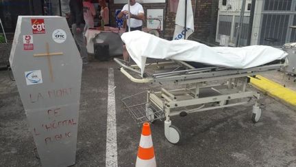 Vendredi 2 août, un piquet de grève sous forme de cercueil a été installé symboliquement devant l'hôpital d'Epinal pour informer les patients. (HERVÉ TOUTAIN/ RADIO FRANCE)