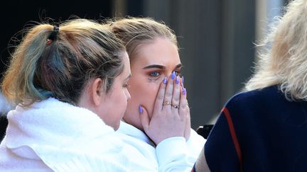 Des jeunes rescapées de l'attentat quittent l'hôtel dans lequel elles ont passé la nuit, mardi 23 mai 2017 à Manchester (Royaume-Uni).&nbsp; (LINDSEY PARNABY / ANADOLU AGENCY / AFP)