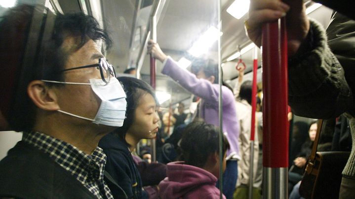 Une femme porte un masque dans le m&eacute;tro de Hong Kong (Chine), le 22 d&eacute;cembre 2003. (PETER PARKS / AFP)