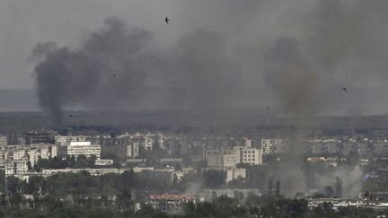 Des panaches de fumée et de poussière s'élève au-dessus de&nbsp;Sievierodonetsk (est de l'Ukraine) après des bombardements de l'armée russe, le 17 juin 2022. (ARIS MESSINIS / AFP)