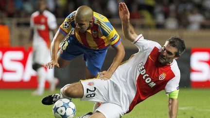 Le joueur de Valence&nbsp;Sofiane Feghouli est tacl&eacute; par le Mon&eacute;gasque J&eacute;r&eacute;my Toulalan, le 25 ao&ucirc;t 2015, lors du match retour des barrages pour la qualification en Ligue des champions, &agrave; Monaco. (JEAN CHRISTOPHE MAGNENET / AFP)