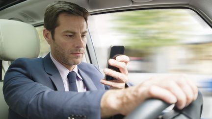 Parmi les conducteurs qui utilisent leur t&eacute;l&eacute;phone au volant, un sur cinq reconna&icirc;t m&ecirc;me consulter ou envoyer des SMS. (FREDERIC CIROU / ALTOPRESS / AFP)