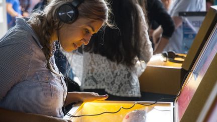 Une femme écoute un livre audio durant le salon international du livre, au Costa Rica, le 13 mai 2019. (PHOTO D'ILLUSTRATION / EZEQUIEL BECERRA / AFP)