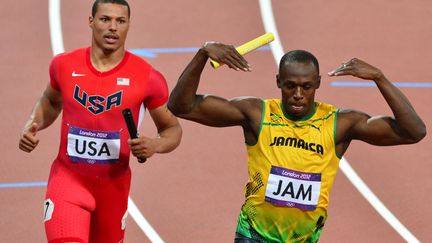 Usain Bolt f&ecirc;te son titre devant l'Am&eacute;ricain Ryan Bailey sur le 4x100m le 11 ao&ucirc;t 2012 &agrave; Londres. (GABRIEL BOUYS / AFP)