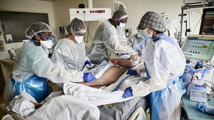 Des soignants prennent en charge un patient atteint du Covid-19 dans le service de réanimation de l'Institut mutualiste Montsouris à Paris, le 6 mai 2021. (ANTONIN BURAT / HANS LUCAS / AFP)