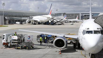 Des agents au sol pr&eacute;parent un avion de la compagnie Air France, le 18 ao&ucirc;t 2014, &agrave; l'a&eacute;roport de Roissy-Charles-de-Gaulle.&nbsp; (KENZO TRIBOUILLARD / AFP)