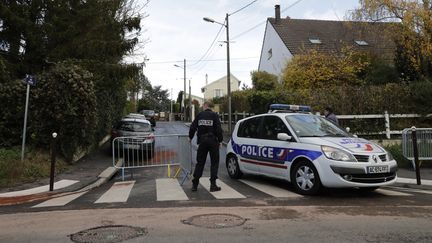 Un policier patrouille devant l'endroit où un de ses collègues a tué trois personnes avant de se suicider, le 18 novembre 2017 à Sarcelles (Val-d'Oise). (THOMAS SAMSON / AFP)