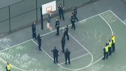 Capture d'&eacute;cran d'n homme arm&eacute; d'un marteau et accroch&eacute; &agrave; un panier de basket sur le terrain de&nbsp;Cal Anderson Park le 1er mai 2015 &agrave;&nbsp;Seattle (Etat de Washington) (CBS / EVN )