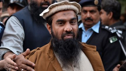 Le cerveau pr&eacute;sum&eacute; des attaques de Bombay en 2008, Zakiur&nbsp;Rehman Lakhvi, est escort&eacute; par les forces de l'ordre, le 1er janvier 2015, apr&egrave;s une audience au tribunal d'Islamabad (Pakistan). (AAMIR QURESHI / AFP)