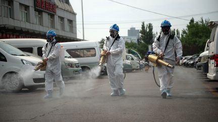 Des membres de l'équipe Beijing Blue Sky Rescue procèdent à la désinfection du marché de gros de Yuegezhuang à Pékin, en Chine, le 16 juin 2020.&nbsp; (CHEN ZHONGHAO / XINHUA / AFP)