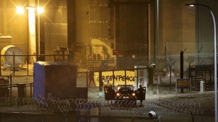 Des gendarmes font face à des militants de Greenpeace qui se sont introduits dans la centrale nucléaire de Cattenom (Moselle), le 12 octobre 2017. (ALEXANDRE MARCHI / MAXPPP)