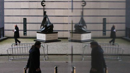 Des pi&eacute;tons passent devant la statue symbolisant l'euro au Parlement europ&eacute;en &agrave; Bruxelles (Belgique), le 6 d&eacute;cembre 2011. (ZHOU LEI / LANDOV / MAXPPP)