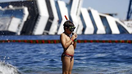 Un jeune vacancier s'appr&ecirc;te &agrave; plonger aux abord de l'&eacute;pave du Costa Concordia, Giglio Porto (Italie), le 28 ao&ucirc;t 2012. (ALESSANDRO BIANCHI / REUTERS)