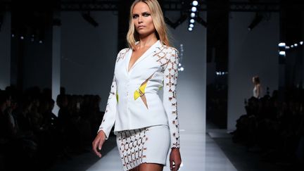 Donatella Versace a présenté des silhouettes de séductrices sûres de leur pouvoir. Les robes épousent les courbes, le corps se révèle sous des broderies et des filets brillants évoquant des toiles d'araignée. Le pantalon fuseau des années 1980 se porte avec des talons aiguilles et une petite veste courte pour un total look d'un blanc éclatant. Les jambes sont mises en valeur par de courtes robes bustiers  scintillantes mais aussi de longues robes blanches, noires ou corail, fendues sur le devant. Cordes et sangles s'attachent autour du corps, bougeant au gré des mouvements. Le casting du show comprenait quelques-uns des top models les plus en vue du moment, comme l'Américaine Gigi Hadid.
 (Thibault Camus/AP/SIPA)