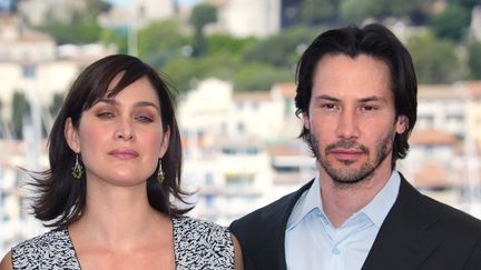 Keanu Reeves et Carrie-Anne Moss, acteurs principaux de la saga Matrix, à Cannes à l'occasion de la sortie de "Matrix Reloaded", le 15 mai 2003. (FRANCOIS GUILLOT / AFP)