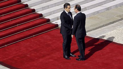 Le pr&eacute;sident sortant Nicolas Sarkozy (G) accueille Fran&ccedil;ois Hollande &agrave; son arrive au palais de l'Elys&eacute;e. (CHRISTOPHE ENA / AFP)