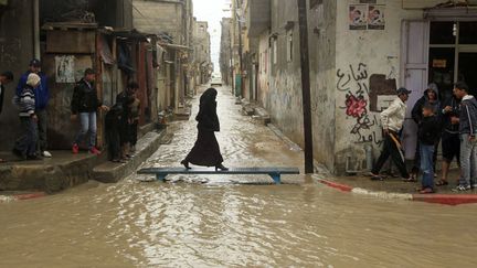 Une femme traverse une rue inond&eacute;e &agrave; Gaza (Palestine), le 1er f&eacute;vrier 2012. (MOHAMMED ABED / AFP)