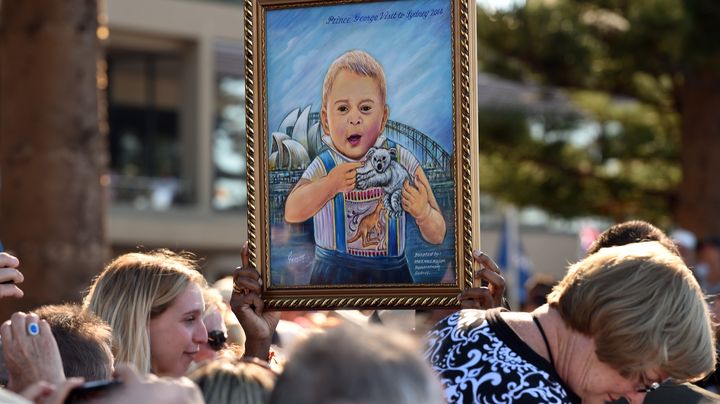 Un tableau du prince Georges brandi par la foule, le 18 avril 2014 &agrave; Sydney (Australie). (WILLIAM WEST / AFP)