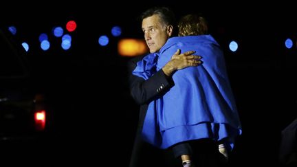 J-4 #TEAMROMNEY Le candidat r&eacute;publicain Mitt Romney tient dans ses bras un de ses petits-enfants &agrave; la sortie de son avion de campagne &agrave; Portsmouth (New Hampshire), dans la nuit de vendredi &agrave; samedi 3 novembre 2012. (CHARLES DHARAPAK / AP / SIPA)