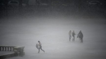 Des personnes tentent de se mettre à l'abri alors qu'éclate un orage à Lyon le 03/09/10 (AFP Jean-Philippe Ksiazek)