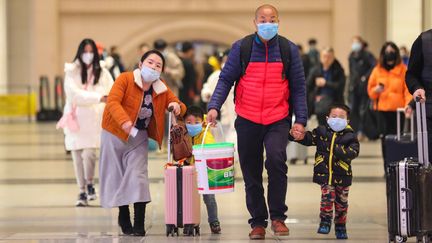 Une famille équipée de masques dans la gare de Hankou, à Wuhan, mardi 21 janvier 2020.&nbsp; (YUAN ZHENG / FEATURECHINA / MAXPPP)