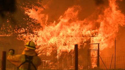 Un pompier observe une maison en flammes à Lakeport en Californie, le 30 juillet 2018.&nbsp; (JOSH EDELSON / AFP)