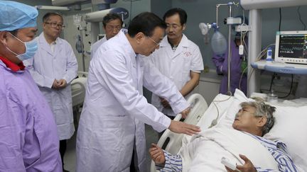 Le Premier ministre chinois Li Keqiang parle à un patient, dans un hôpital de Jianli (province de Wuhan), le 2 juin 2015. (REUTERS / cnsphoto CHINA OUT)