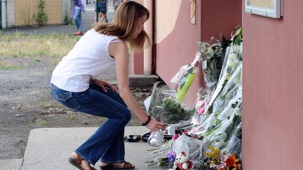 Une femme d&eacute;pose des fleurs devant l'&eacute;cole Edouard-Herriot, &agrave; Albi (Tarn), le 5 juillet 2014. (REMY GABALDA / AFP)