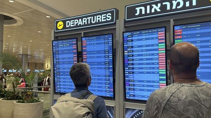 Des personnes regardent le tableau de bord des départs à l'aéroport international Ben Gourion à Tel Aviv, le 8 octobre 2023. (TURGUT ALP BOYRAZ / ANADOLU AGENCY)