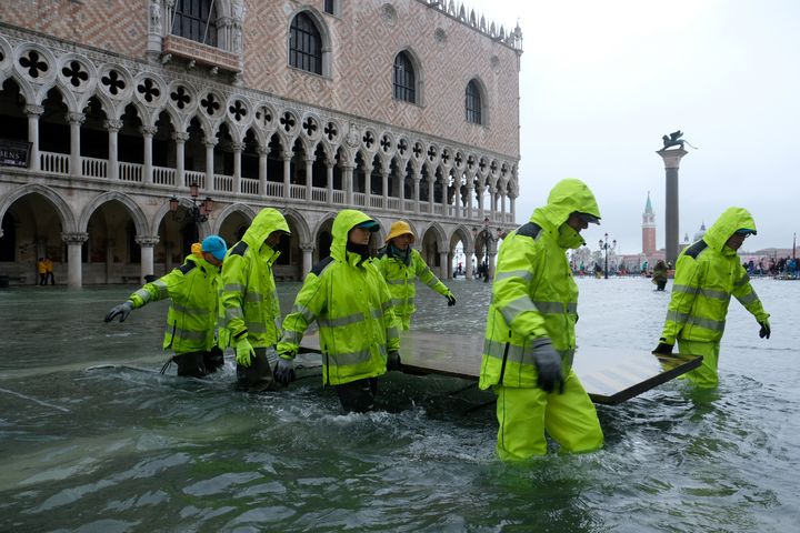 Des ouvriers traversent la place Saint-Marc, le 12 novembre 2019 à Venise (Italie). (MANUEL SILVESTRI / REUTERS)