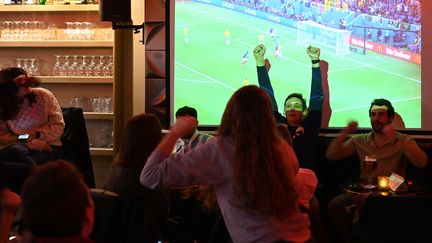 Des supporters de la France fêtent un but des Bleus contre l'Australie dans un bar à Paris, le 22 novembre 2022. (ALAIN JOCARD / AFP)