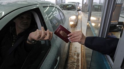 Un Serbe présente son passeport à Horgos, à la frontière entre la Serbie et la Hongrie, le 19 décembre 2009. (ANDREJ ISAKOVIC / AFP)