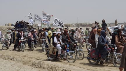 Des soutiens des talibans arborent le drapeau taliban dans la ville de Chaman, au Pakistan, à la frontière avec l'Afghanistan, le 14 juillet 2021. (TARIQ ACHAKZAI / AP / SIPA)