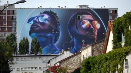 Le portrait des deux frères de PNL, peint sur un immeuble d'Ivry-sur-Seine, en 2019. (LIONEL BONAVENTURE / AFP)